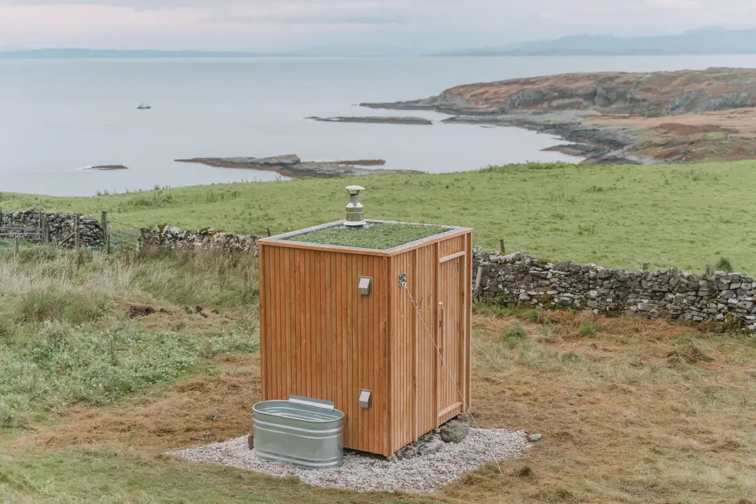Ardna timber sauna with a sedum roof and outdoor tub overlooking the coast at Ardnamurchan